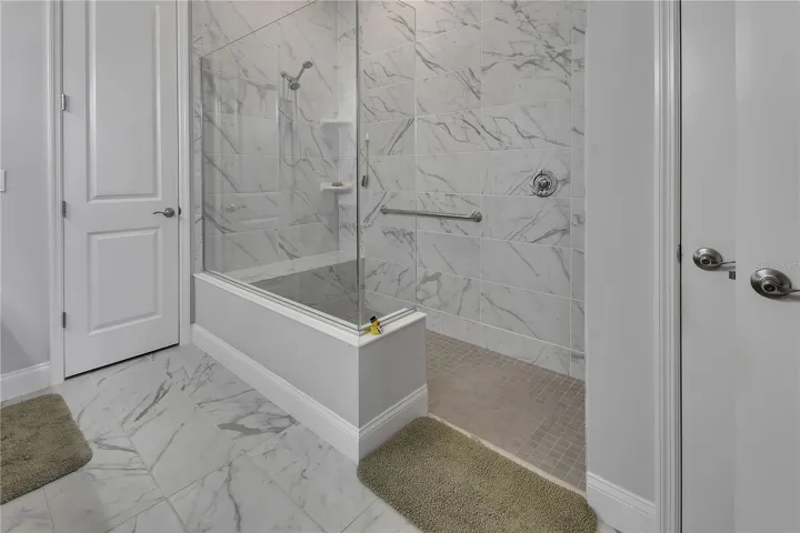 Walk-in shower has bench and grab bar. Privacy Lavatory.