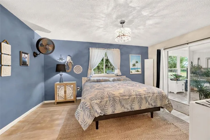 Primary Bedroom with direct access to the Florida room with sliders for light and curtains for privacy. Its the best of both worlds. Private Lot with lots of natural light. A pretty view from every room