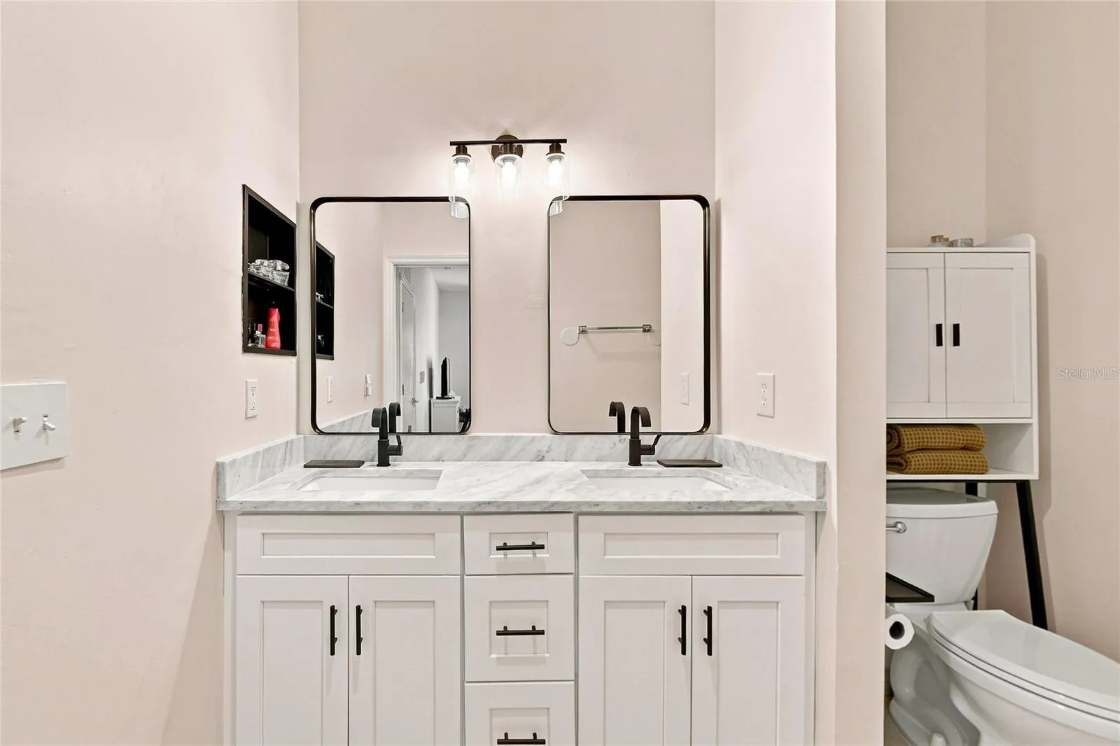 Updated primary bathroom with dual sinks and mirrors