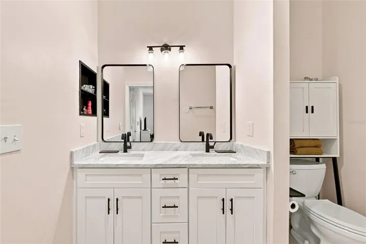 Updated primary bathroom with dual sinks and mirrors