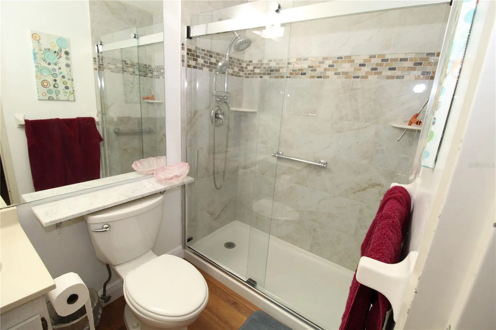 Primary bathroom with beautiful step in shower.  Updated shower doors and tile add style and elegance.