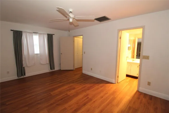 Primary bedroom is spacious. Laminate wood flooring adds warmth to this entire home.