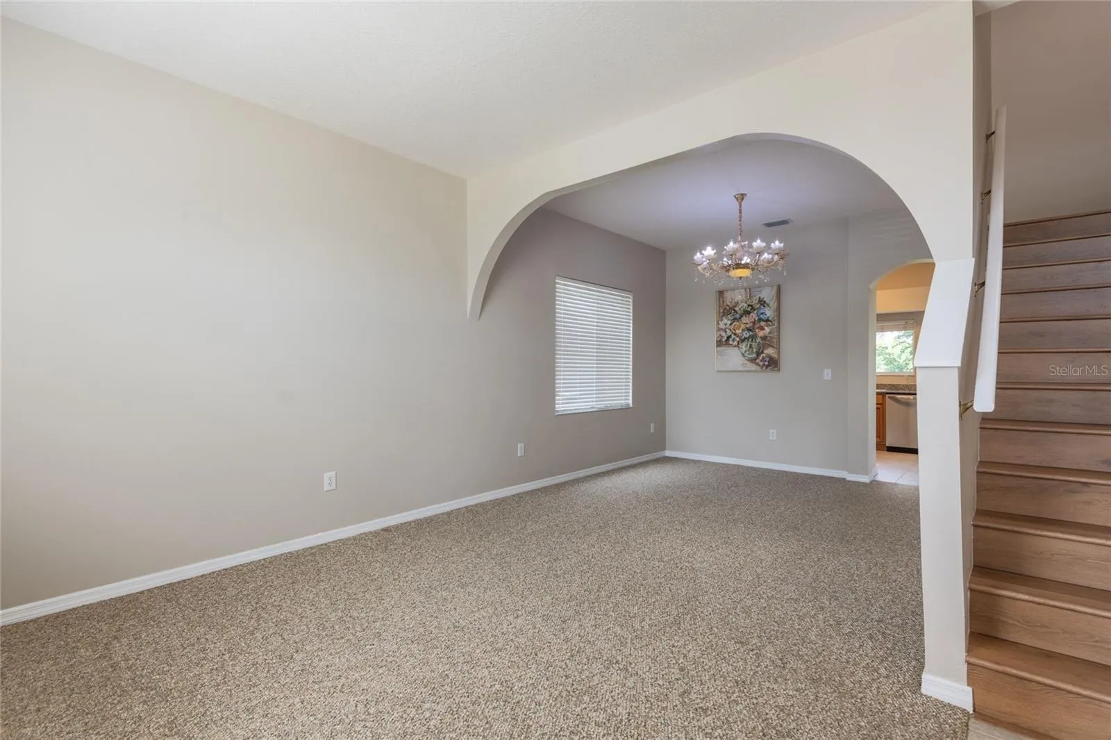 The interior begins with an expansive formal living room leading into a dining area