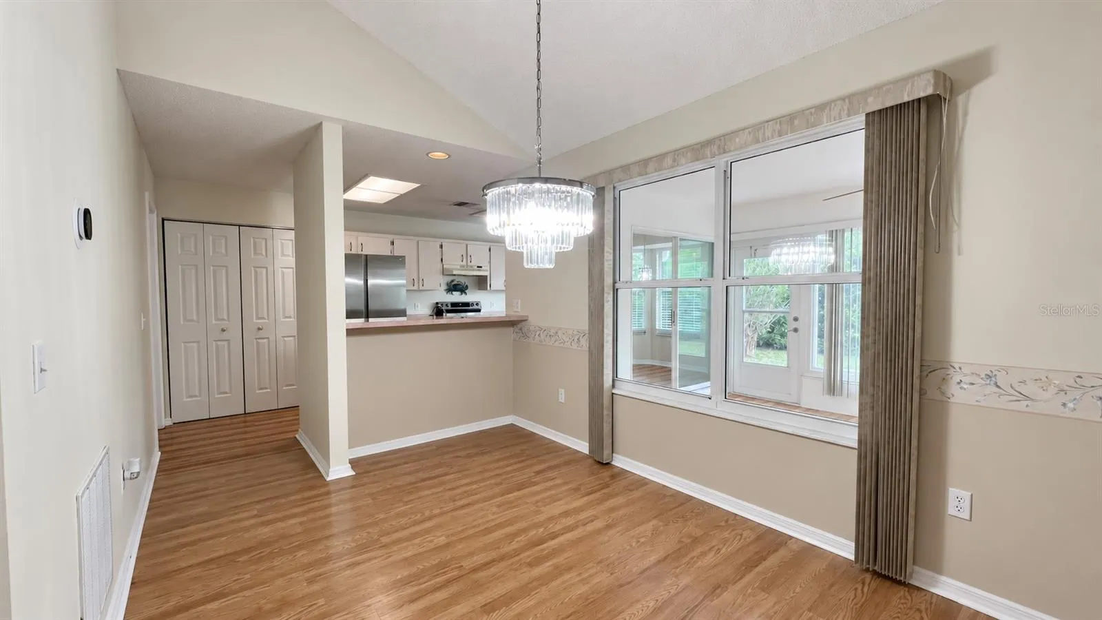 Dining room leading into the large kitchen and facing the enclosed lanai.