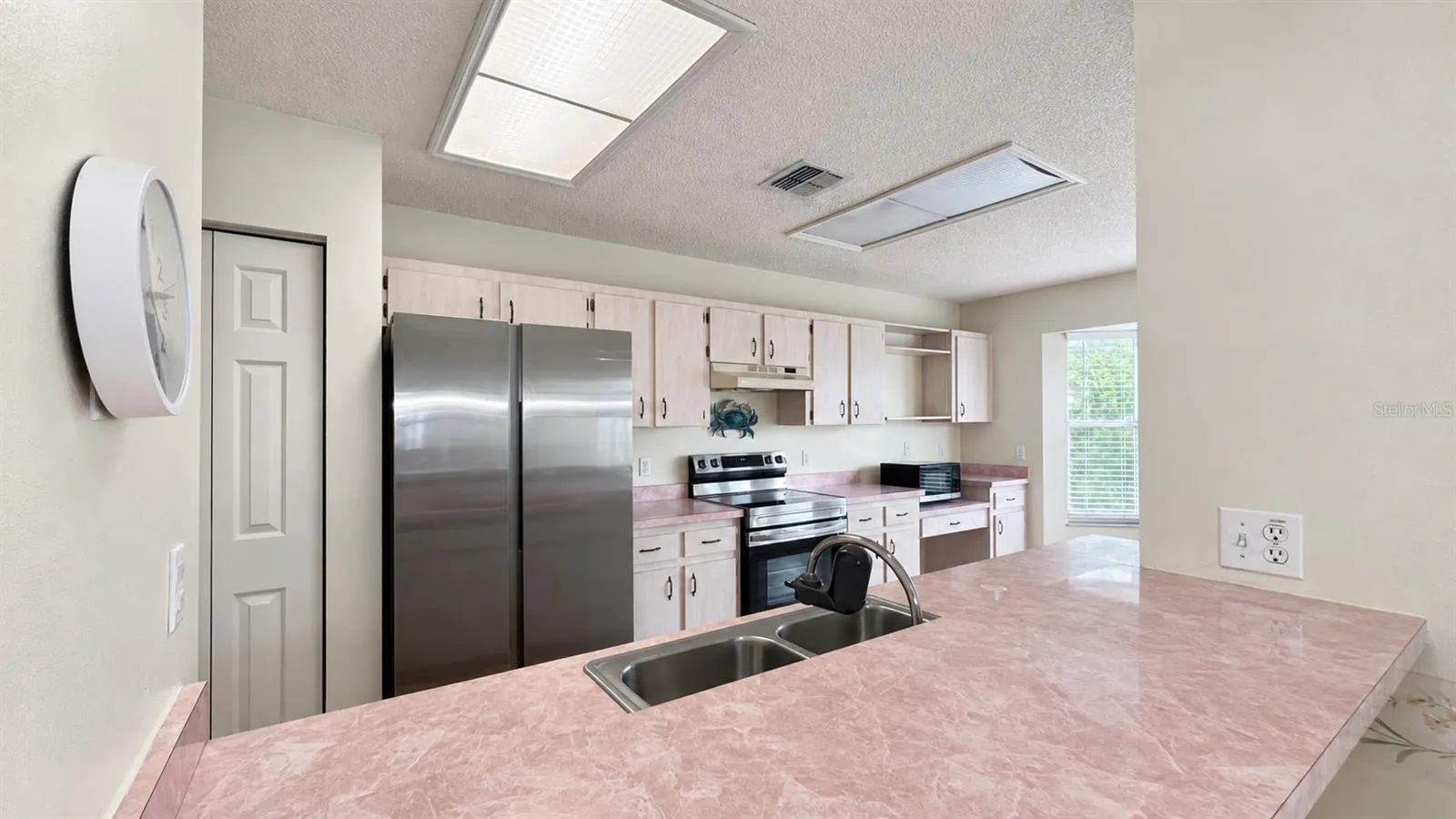 Large kitchen facing the enclosed lanai and backyard.