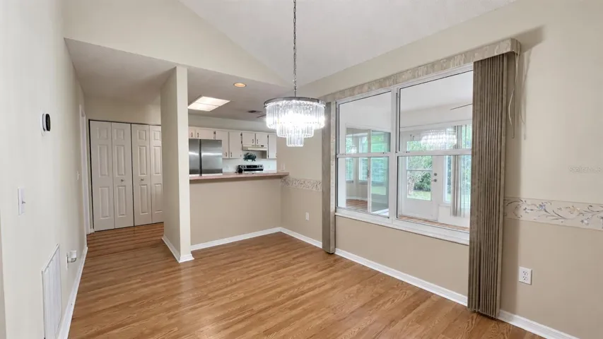 Dining room leading into the large kitchen and facing the enclosed lanai.