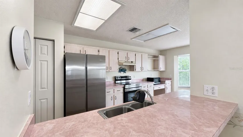 Large kitchen facing the enclosed lanai and backyard.