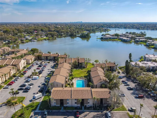Front view of unit in center of 3 buildings with pool an lake in background of unit