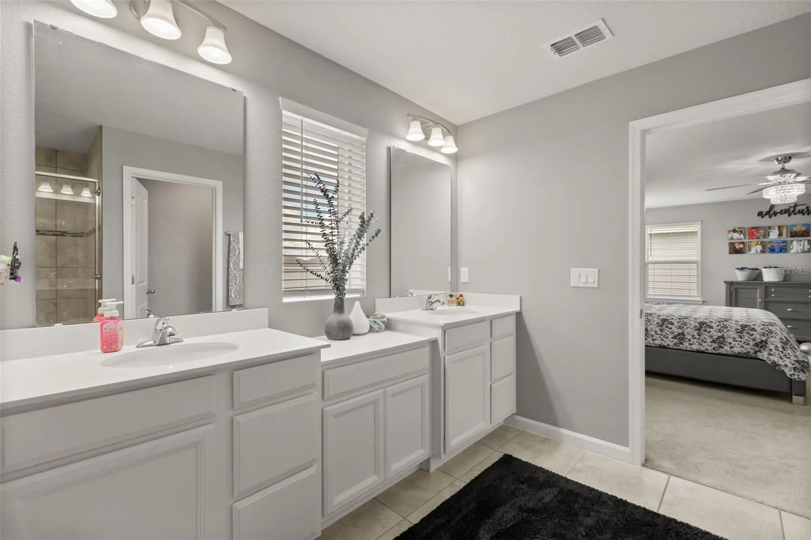 Primary bath features dual vanities with solid-surface tops.