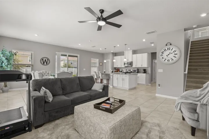 View from family room showing service island, kitchen, and staircase to second floor.