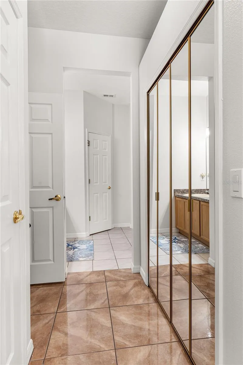 Primary bedroom walk-in closet is in-between the bedroom and the bathroom