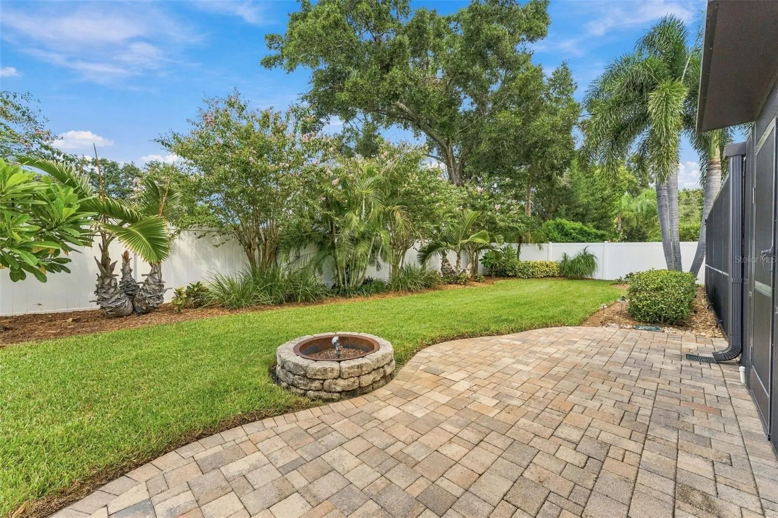 Beautifully Maintained Backyard with Paver Patio & Inviting Fire-Pit Area