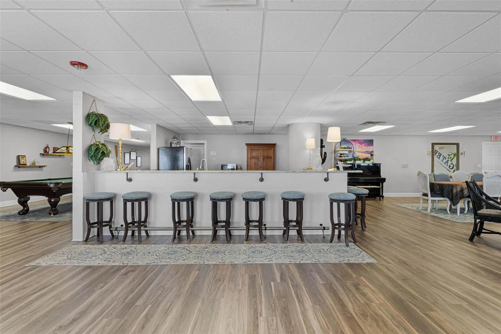 Clubhouse kitchen with bar seating and pool table.