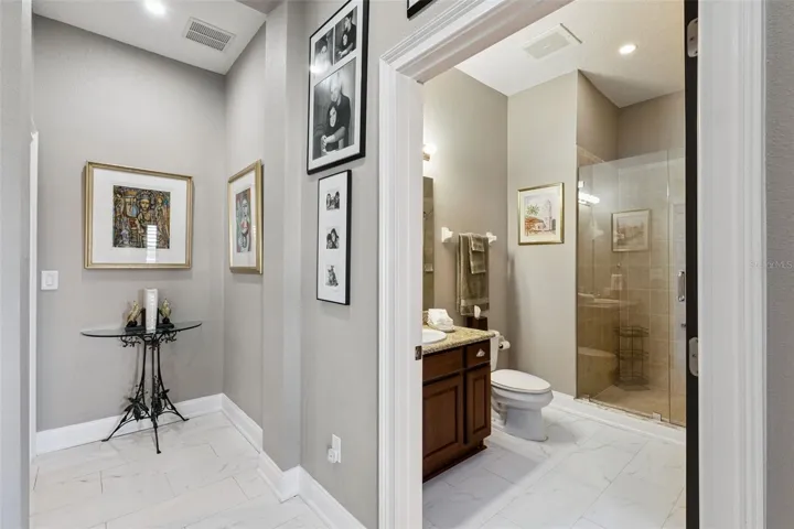 Hallway bathroom with updated seamless glass shower.