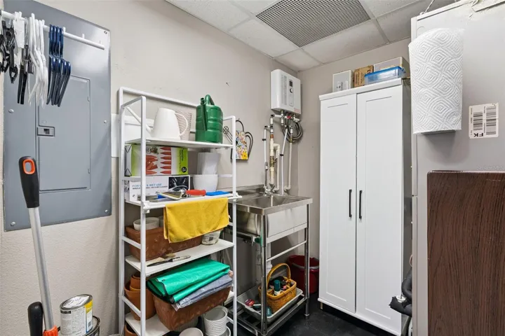 Utility closet with sink and storage.