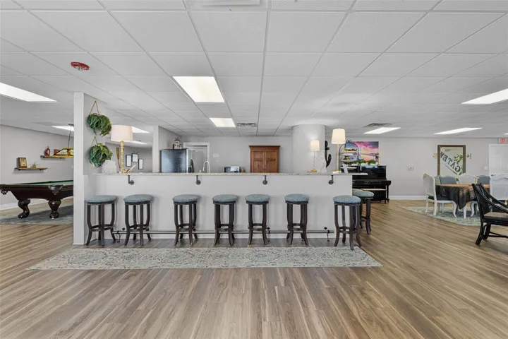 Clubhouse kitchen with bar seating and pool table.
