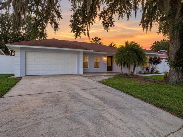 Front exterior view with spacious driveway and attached two-car garage.