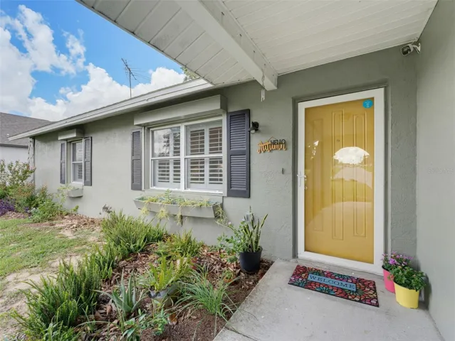 CHEERFUL YELLOW FRONT ENTRANCE WITH GLASS STORM DOOR FOR EXTRA LIGHT
