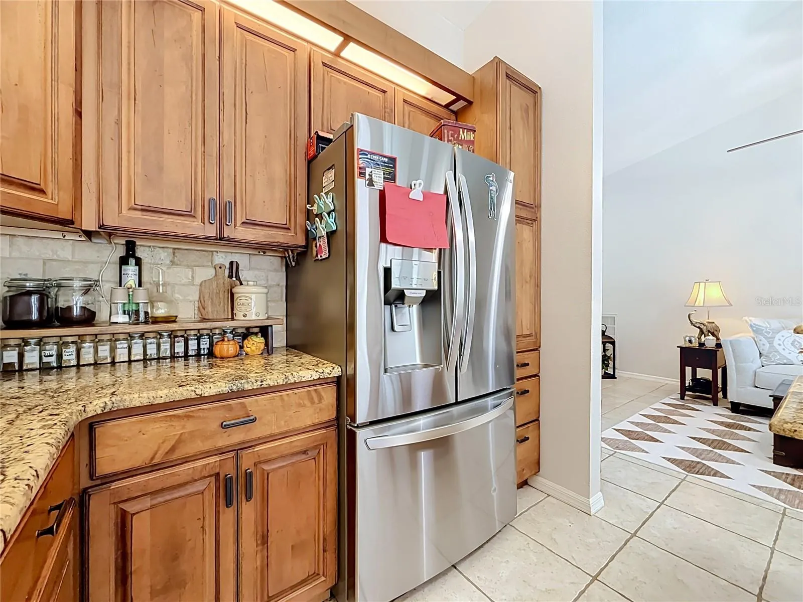remodeled kitchen with wood cabinets, granite countertops, SS appliances.