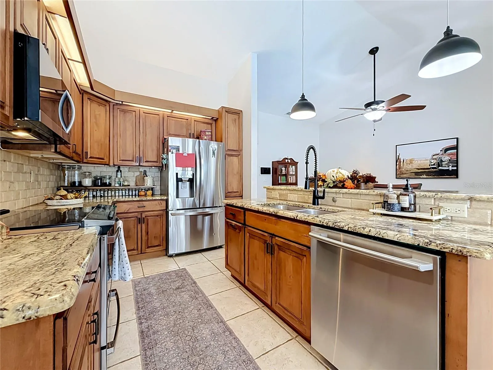 remodeled kitchen with wood cabinets, granite countertops, SS appliances, kitchen island.