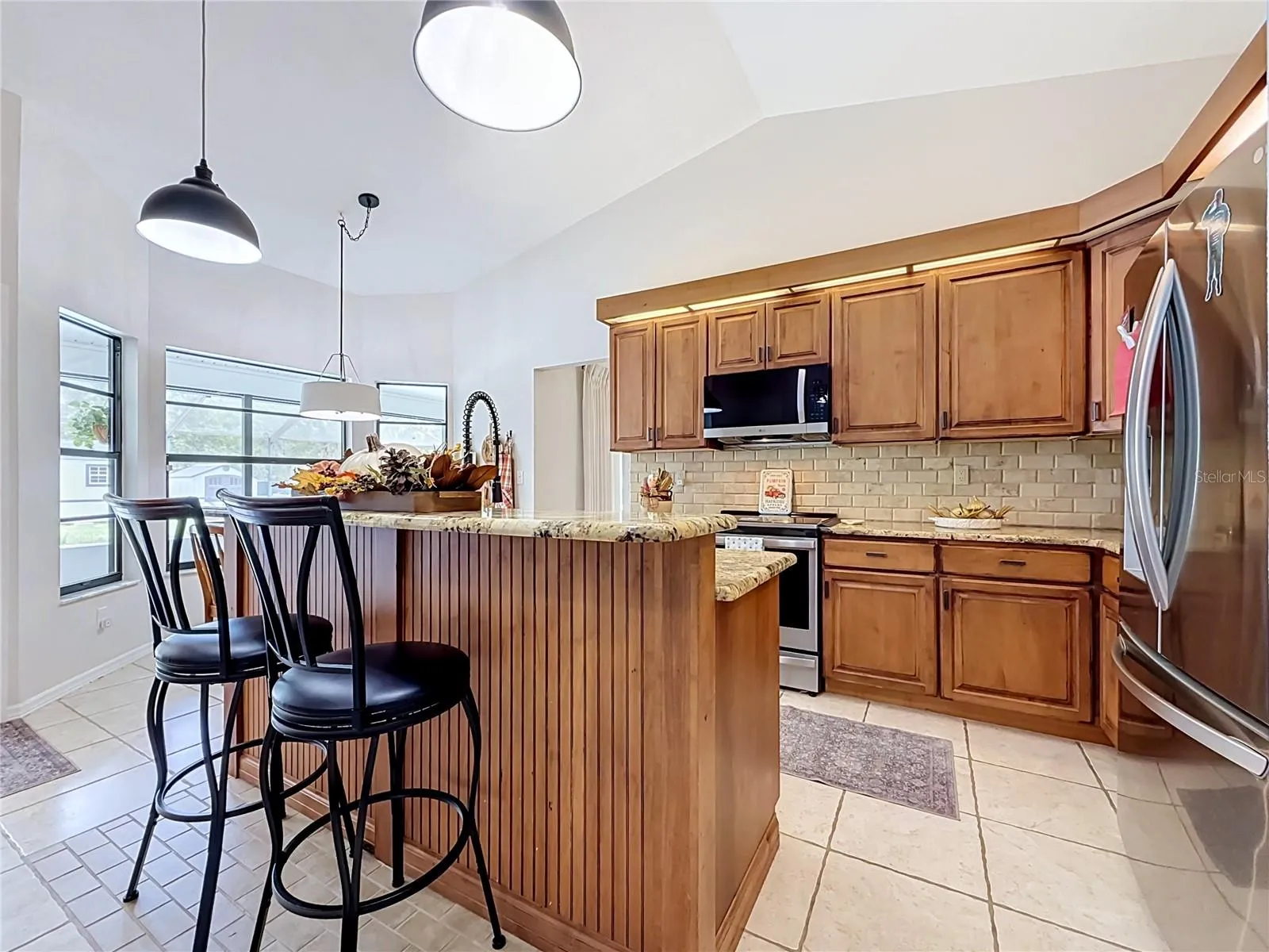 remodeled kitchen with wood cabinets, granite countertops, SS appliances, kitchen island.