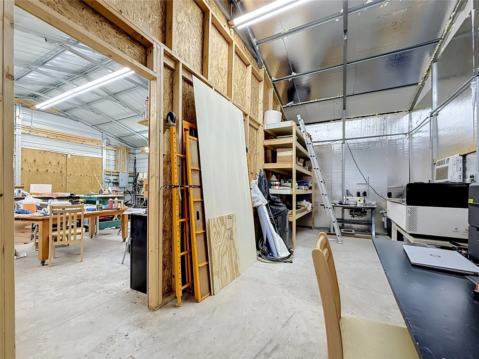 inside the workshop, 2 benches, 2 8X8 built in shelving 18 inches deep, 225 amp sub panel, 3 A/C's
