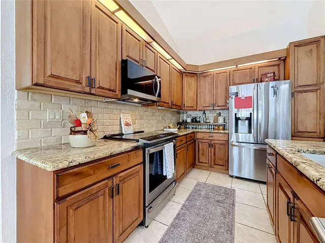 remodeled kitchen with wood cabinets, granite countertops, SS appliances, kitchen island.