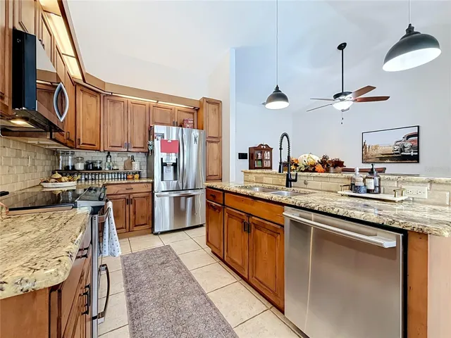 remodeled kitchen with wood cabinets, granite countertops, SS appliances, kitchen island.