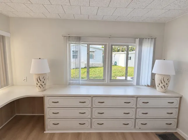 primary bedroom with built in dressers and vanity area