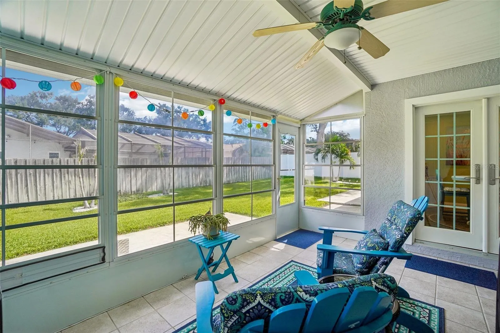 Enclosed Rear Patio – This light-filled enclosed patio features tiled flooring, a ceiling fan, expansive screened/windowed walls, and direct access to both the backyard and interior living spaces.