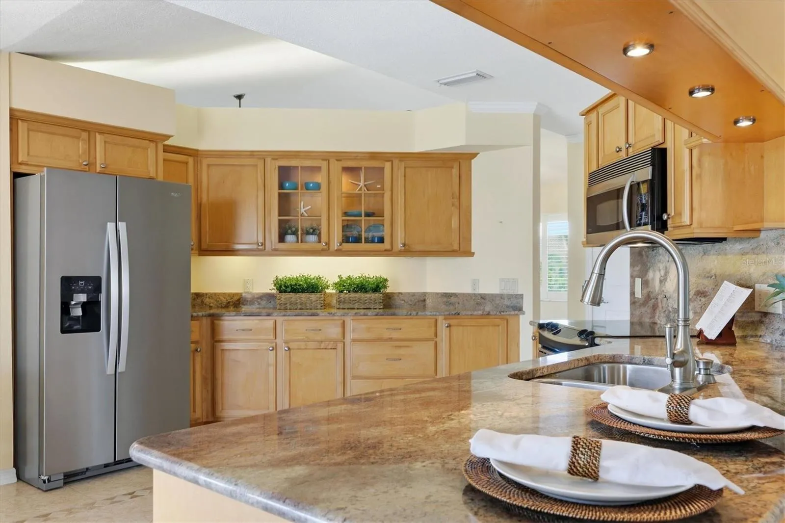Granite countertops, stainless steel appliances, custom cabinetry, under cabinet lighting - light and bright