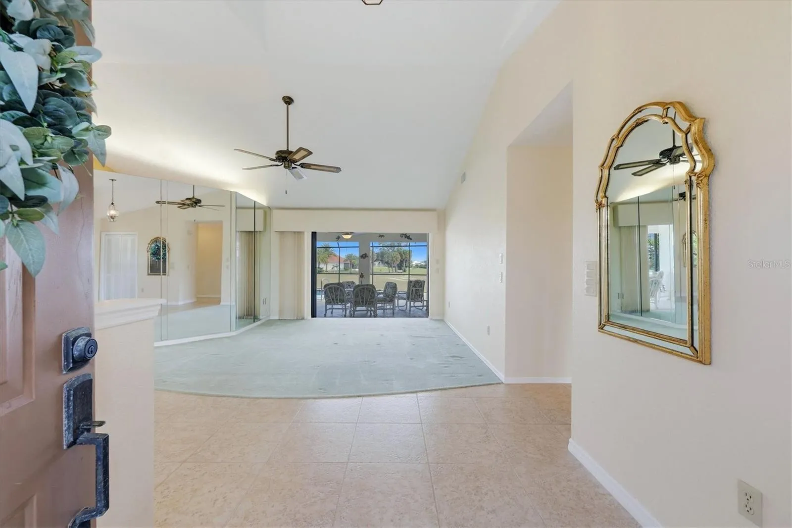 View from foyer toward living room and hide-away sliders to your lanai/pool