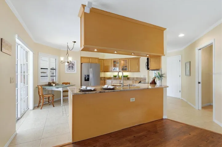 View from the family room to the kitchen and dining nook - sliders to lanai from kitchen