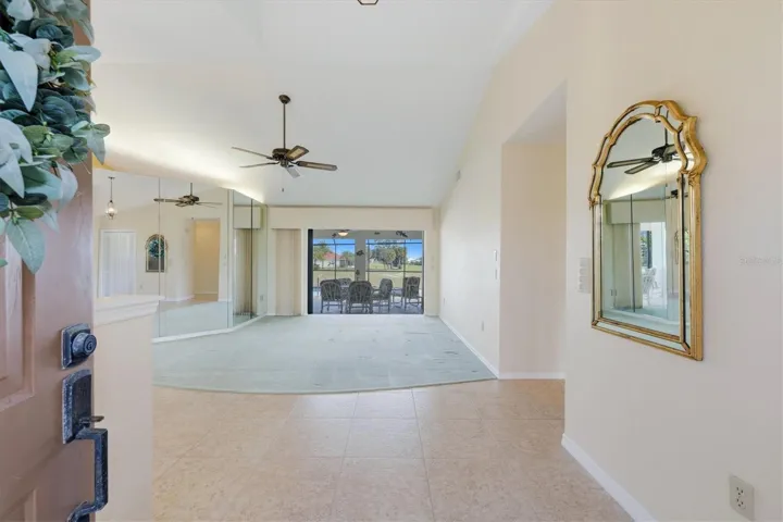 View from foyer toward living room and hide-away sliders to your lanai/pool