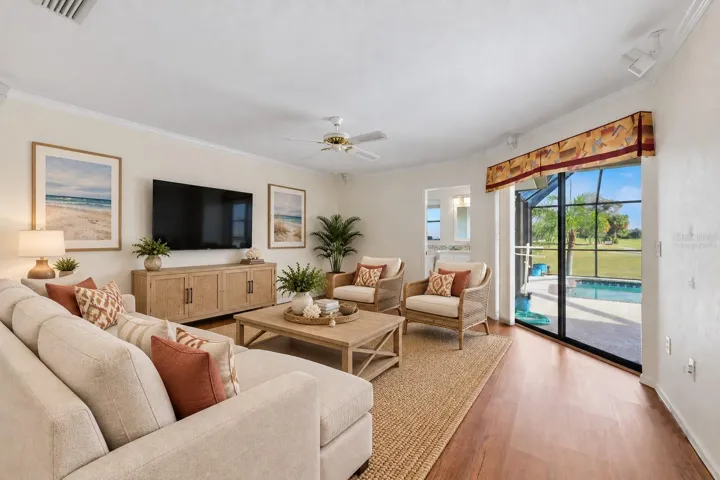 Family room virtually staged for your viewing pleasure, open to the kitchen - full bathroom and sliders to the lanai/pool area