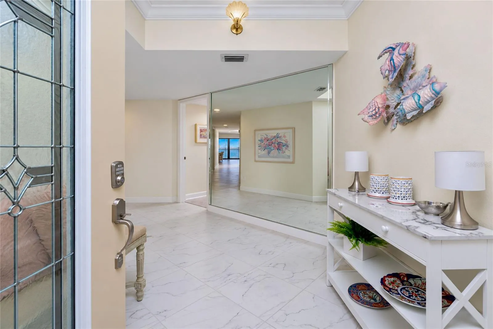 FOYER WITH LARGE TILE AND NICELY ACCENTED MIRRORED WALL