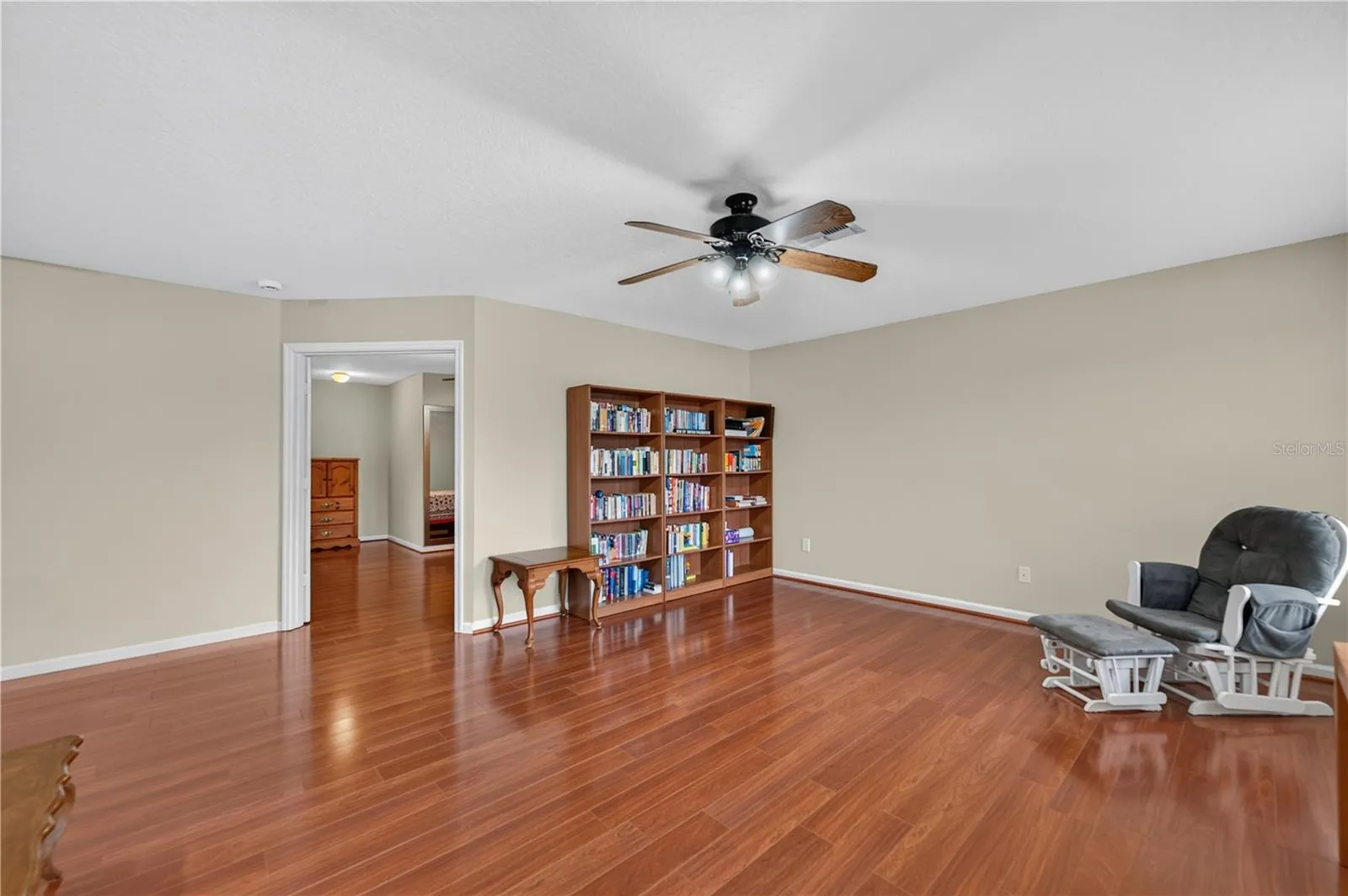 Spacious bonus room with wood flooring, a ceiling fan, and access to bedroom #5 with a full bathroom.