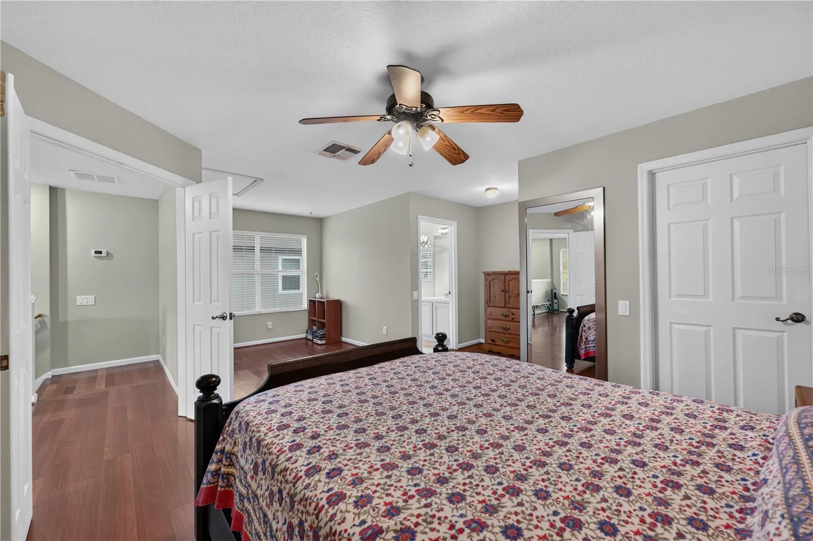 Spacious bedroom #5 with a separate sitting area, high ceilings, wood floorings, and a ceiling fan.