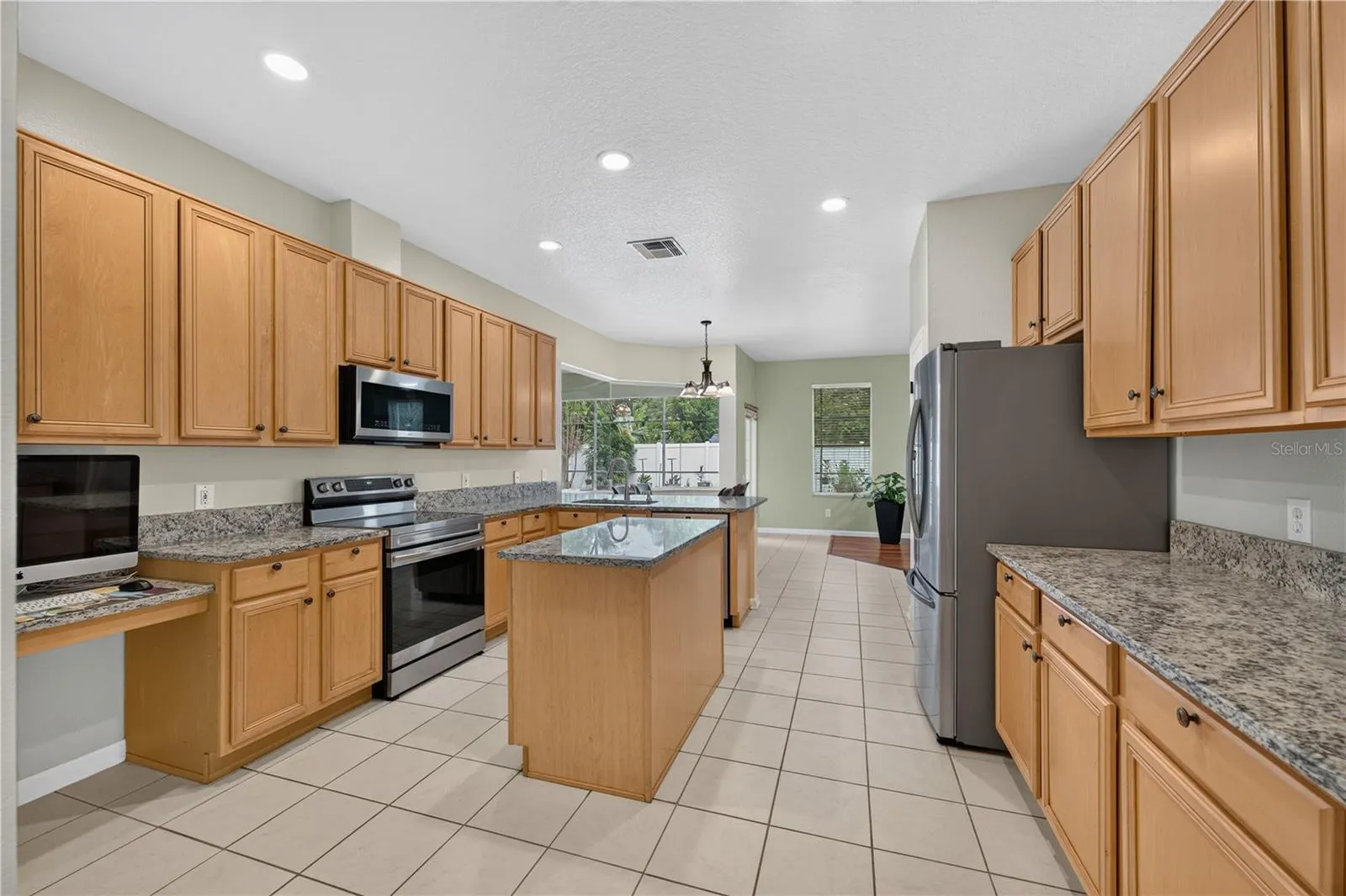 Kitchen featuring abundant cabinetry, granite countertops, stainless steel appliances, and a center island.  Great for entertainment.