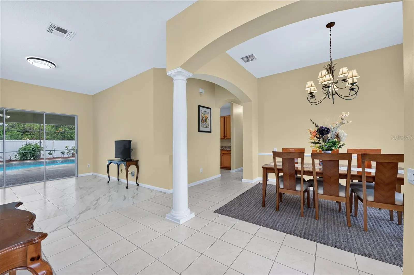 Welcoming entryway with high ceilings, decorative architectural details, and an adjoining formal dining room.