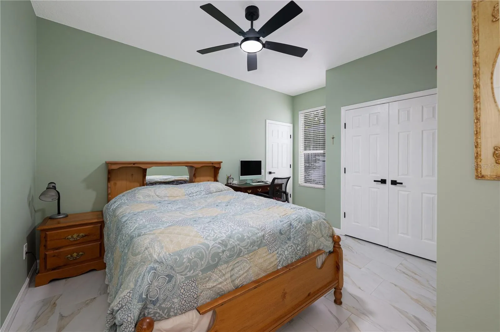 Bedroom #3 featuring high ceilings, a ceiling fan, tile flooring, and ample closet space.