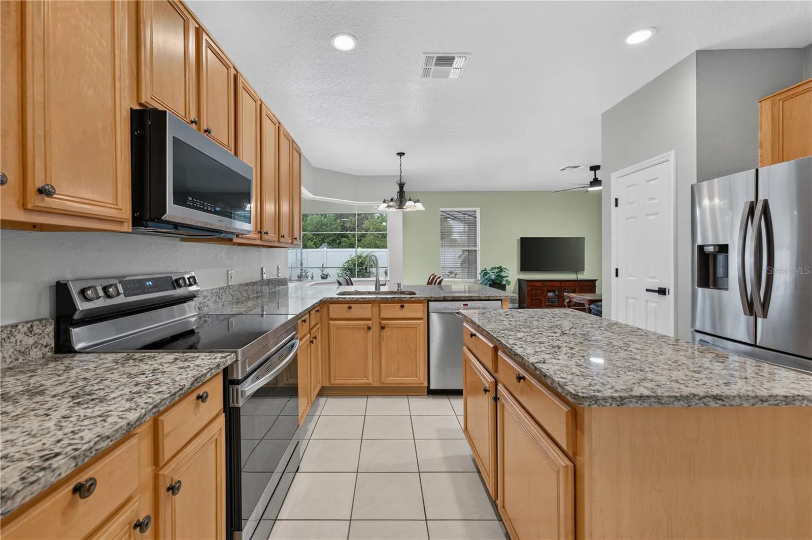 Kitchen featuring abundant cabinetry, granite countertops, stainless steel appliances, and a center island.  Great for entertainment.