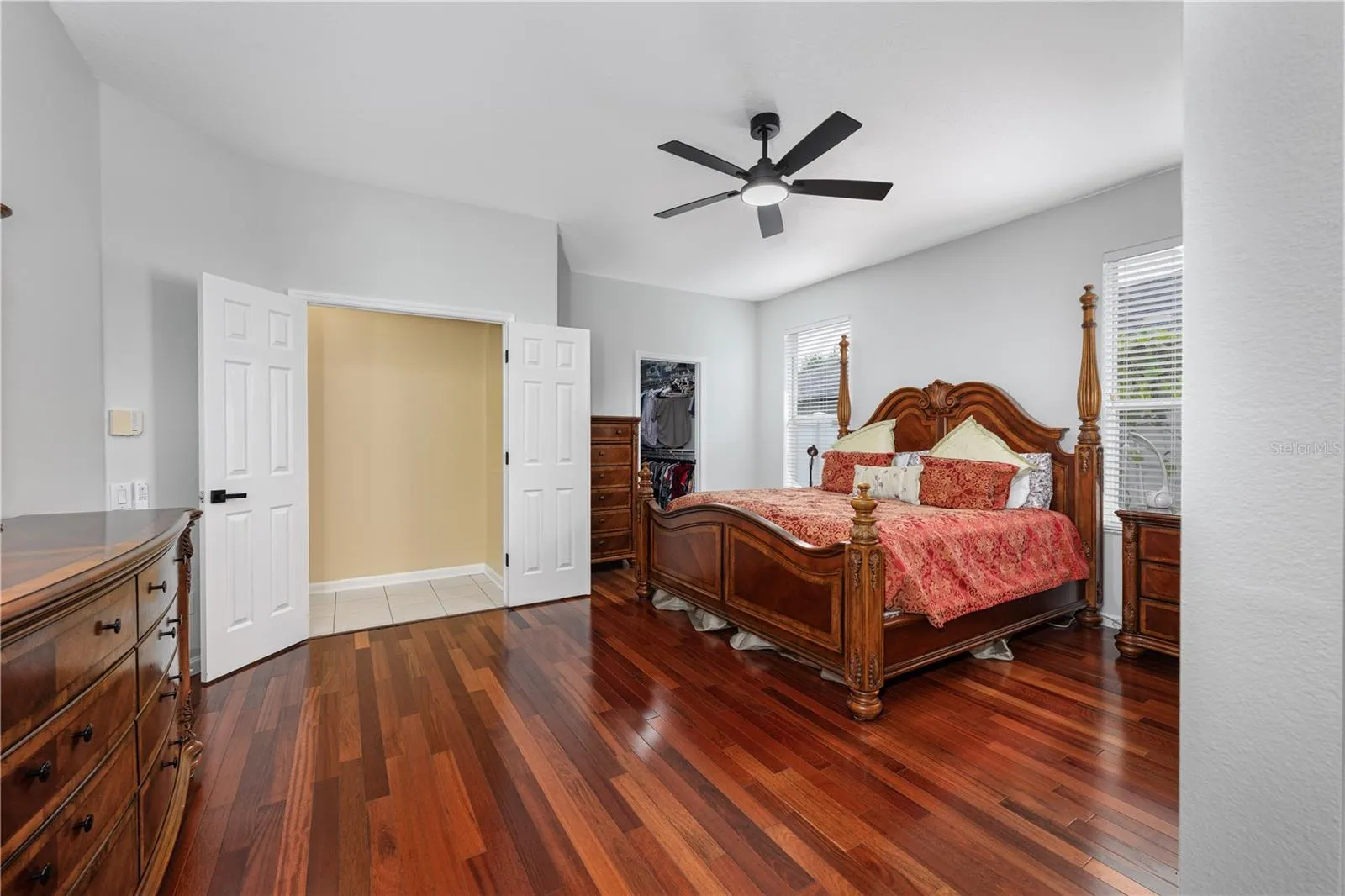 Spacious primary bedroom with wood flooring and a private sitting area.