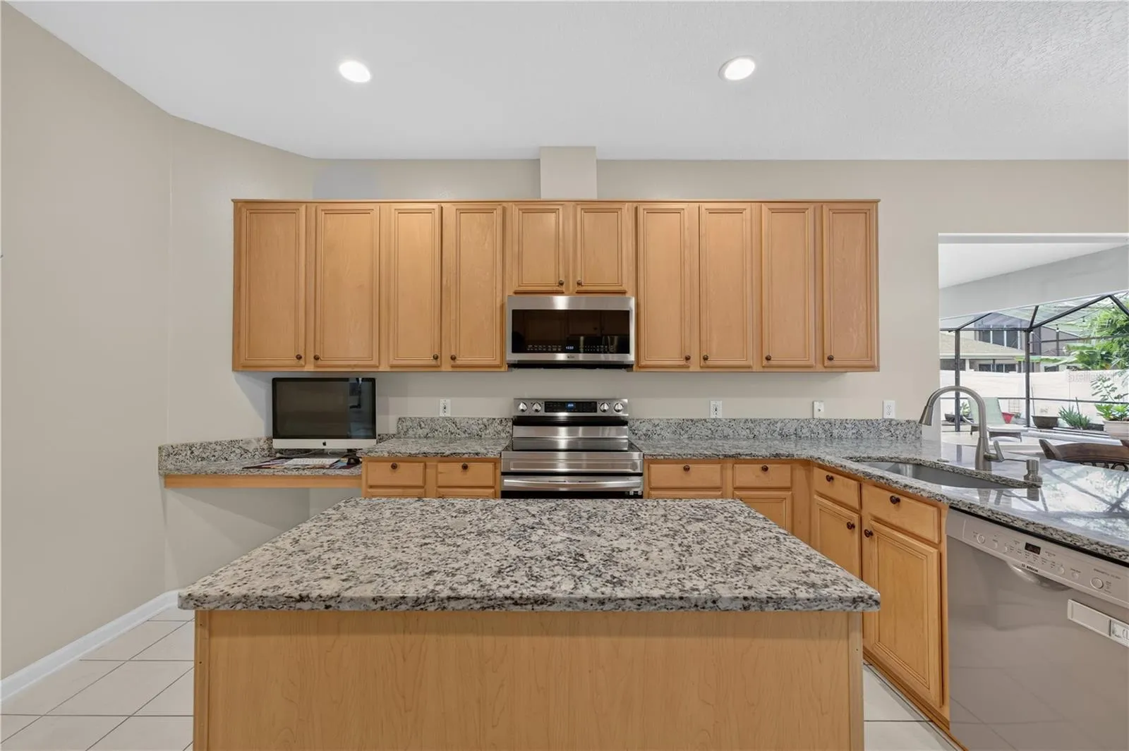 Kitchen featuring abundant cabinetry, granite countertops, stainless steel appliances, and a center island.  Great for entertainment.