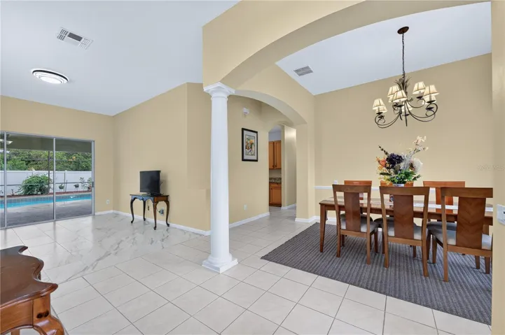 Welcoming entryway with high ceilings, decorative architectural details, and an adjoining formal dining room.