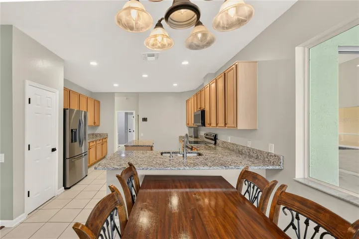 Bright dinette adjoining the kitchen, featuring a breakfast bar and an open, functional layout.
