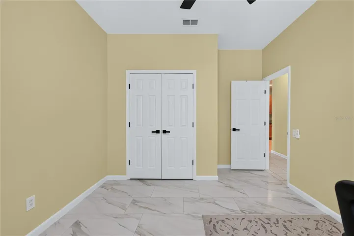 Bedroom #4 with high ceilings, a ceiling fan, and flexible use as a home office.