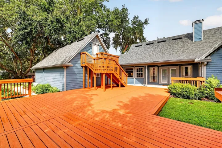 back deck area showing exterior of home, chimney view and stairs to office above garage.