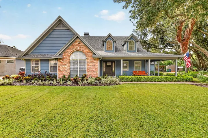 Front of house with brick accent and covered front porch.  View of dormer windows from the exterior of home.