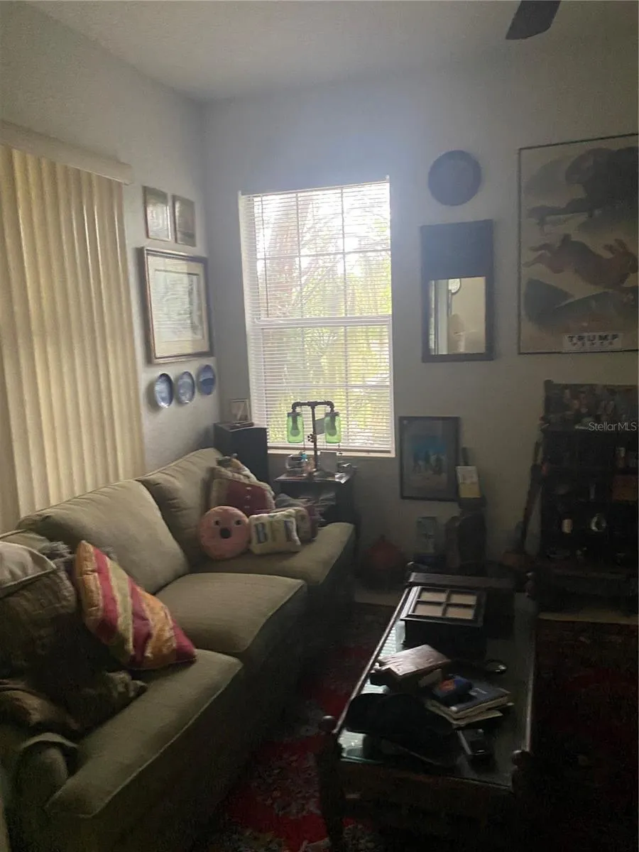Den room with high ceiling, ceiling fan with big windows